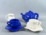 trois tasses et soucoupes bleues et blanches posées sur une table
