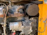 a yellow truck with a large engine in the back of it