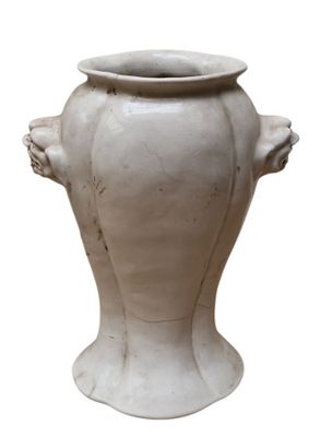 un vase blanc orné d'un visage sur fond blanc