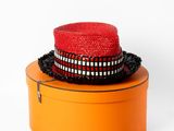 un chapeau rouge posé sur une boîte orange