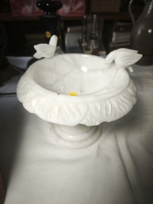 a white bowl with a bird on it on a table
