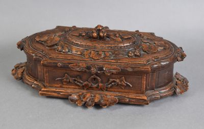 an old wooden box with carvings on it on a gray surface