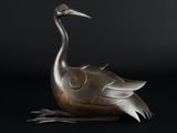 une statue en bronze représentant un oiseau sur fond noir