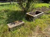 un abreuvoir en pierre posé au milieu d'un champ herbeux