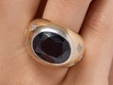 an image of a close up of a person ' s hand wearing a ring with a black stone on it