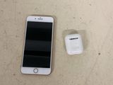 a cell phone and an apple airpods on a table