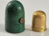 deux dés à coudre posés l'un à côté de l'autre sur une surface blanche