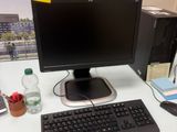 un écran d'ordinateur, un clavier, une souris et d'autres fournitures de bureau posés sur un bureau
