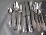 a lot of silverware on a table with a knife and fork