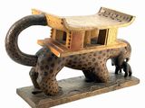 a statue of a leopard with a wooden structure on it ' s back