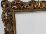 a picture of a gold framed mirror on a white wall