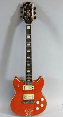 an orange electric guitar sitting on top of a white surface