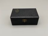 une vieille boîte noire posée sur une table blanche