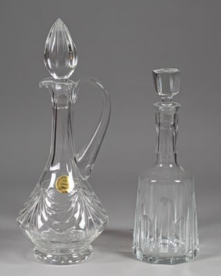 two glass decanters sitting next to each other on a table