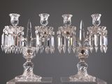 une paire de chandeliers en cristal sur des socles, sur fond gris
