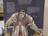 an old comic book sitting on a table with a picture of a man standing next to it