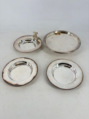 three silverplated dishes and a silver plate on a white surface