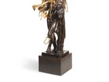 an image of a bronze statue of a man holding a trumpet