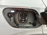 a close up of a car ' s rear end with an electric plugged in