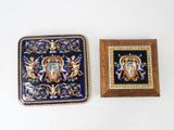 two pieces of blue and gold tile with a picture of a coat of arms on it