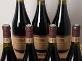 six bottles of wine sit in a wooden crate on a table