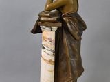 an image of a statue of a woman leaning on a column
