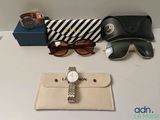 une montre, des lunettes de soleil et un portefeuille posés sur une table
