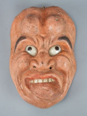 une image représentant un masque en argile accroché au mur