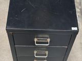 a black filing cabinet sitting on the floor in a room
