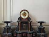 a clock and three stools on the floor next to a wall