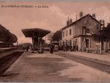 une vieille photo d'une gare où des gens attendent le train