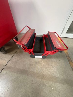 un chariot rouge posé par terre à côté d'une chaise rouge