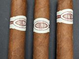 three cigars sitting on top of a table next to each other