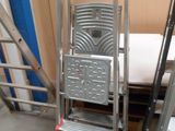 une échelle à côté d'une pile de chaises