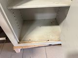 a white cupboard that has a wooden shelf in it