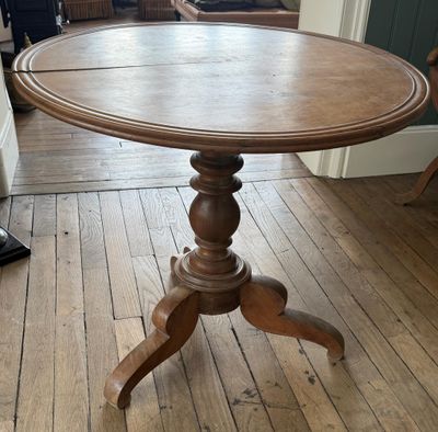 une table en bois avec un plateau en bois posée sur un parquet