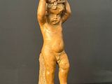 statue of a child holding a basket on his head