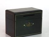 une petite boîte noire ornée d'un emblème doré