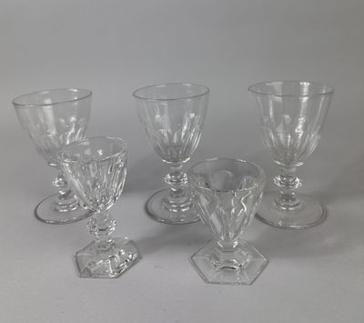four clear glass goblets sitting on top of a white table