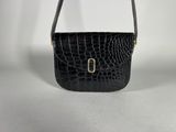 a black crocodile skin purse with a gold clasp