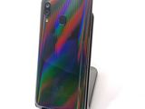 a close up of a cell phone on a stand on a white surface