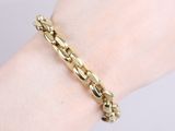 a close up of a person ' s hand wearing a gold bracelet