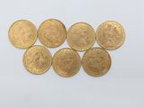 a bunch of gold coins sitting on top of a white surface