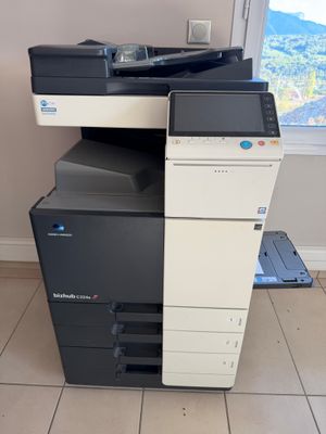 a multi - function printer sitting on the floor in front of a window
