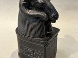 statue of a ram on top of a box on a white surface