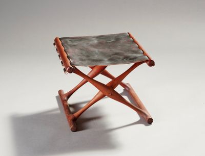 une image représentant un petit tabouret en bois avec une assise en cuir