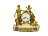a gold clock with a statue on top of it