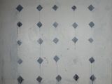 une peinture représentant des losanges bleus et blancs sur un mur blanc