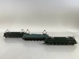 Trois petits trains sont posés sur une surface blanche, devant un fond blanc.