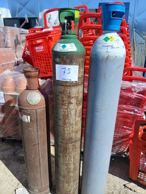 de nombreux types de bouteilles et de récipients de gaz posés au sol